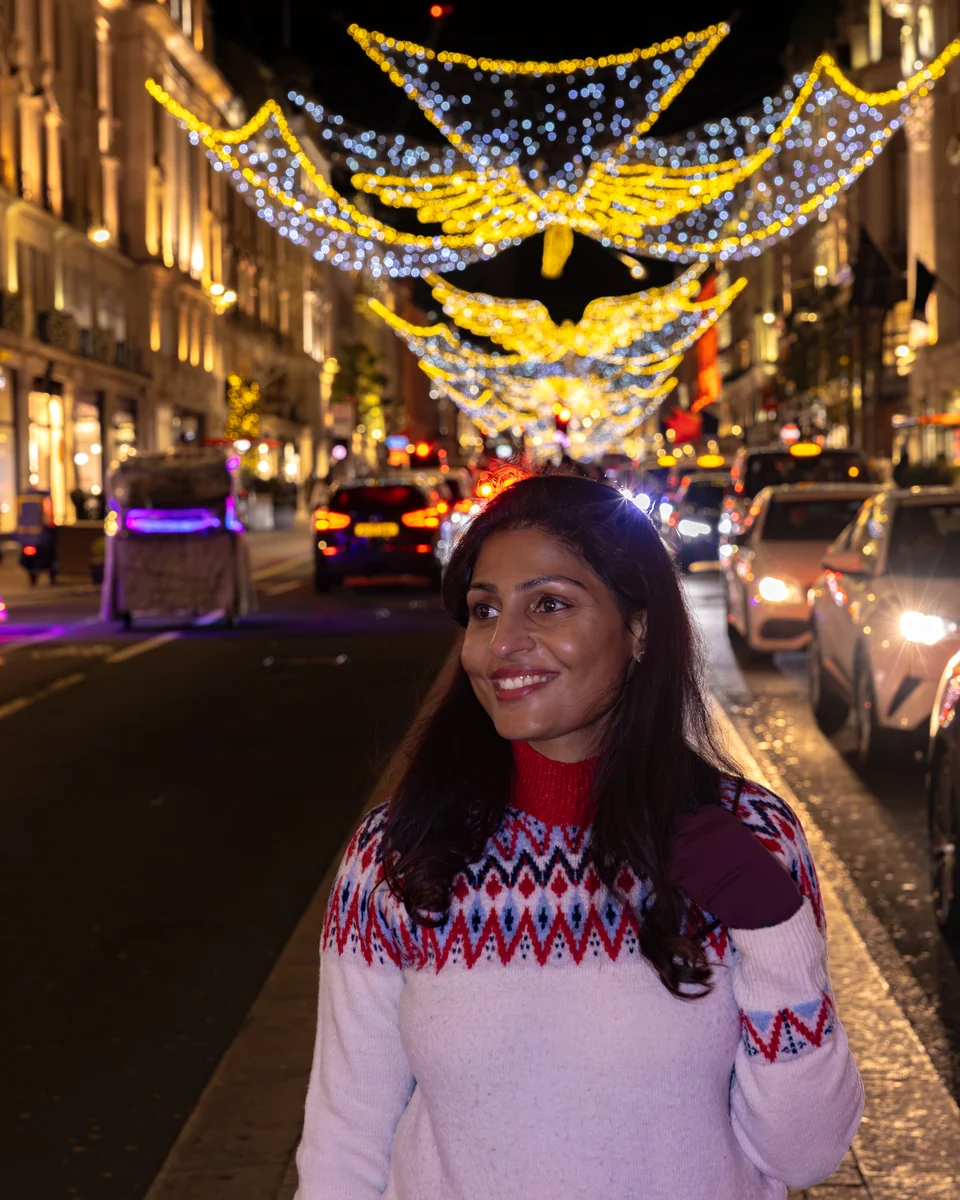 Matty in a patterned winter jumper beneath Regent Street’s Christmas angels.